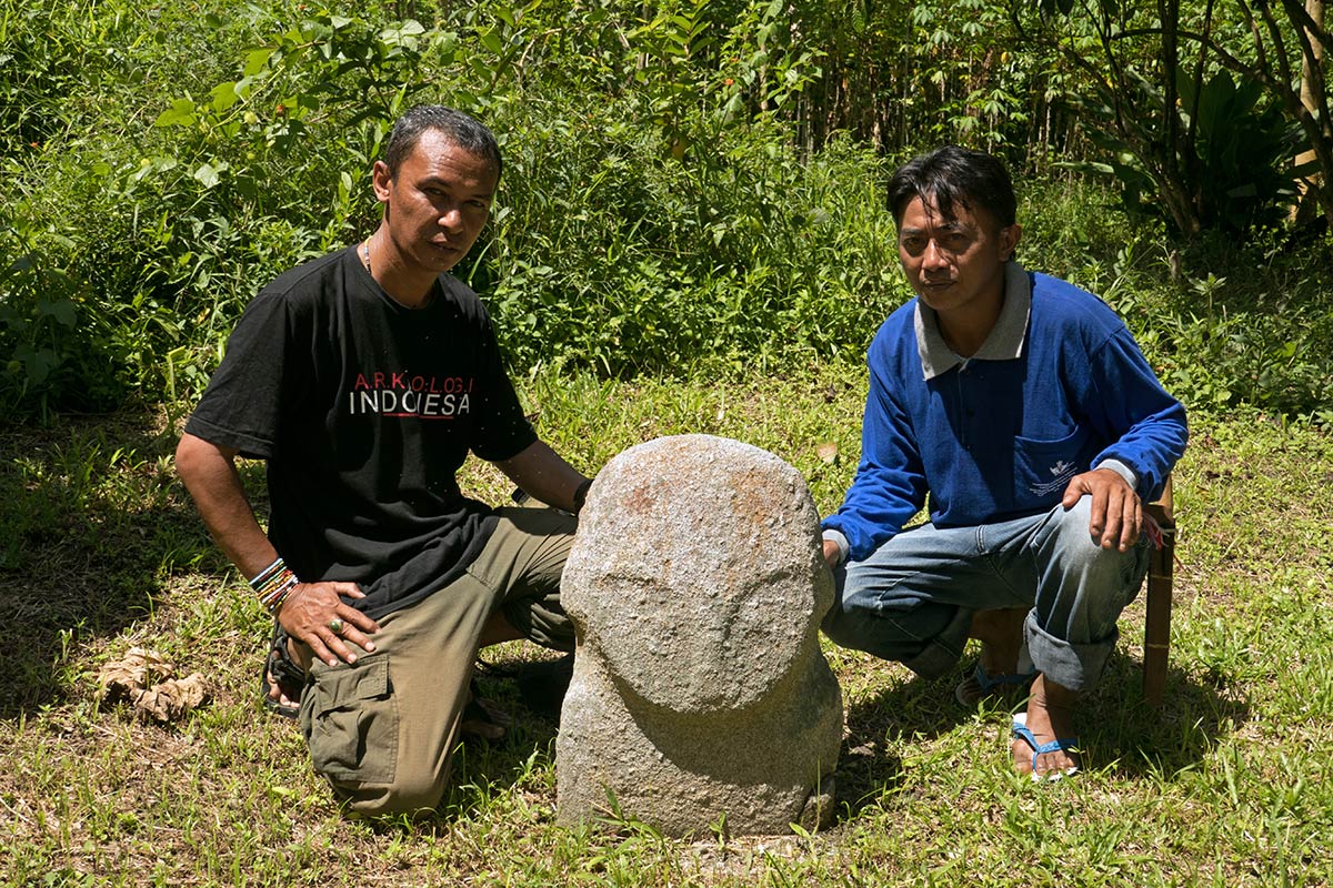 Small statue with archaeologist Iksam Djorimi and local guide, near Gintu village, Bada Valley