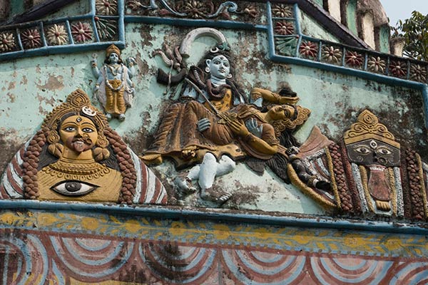 Shiva portant le corps de Shakti tout en faisant la danse sauvage Tandava à travers l'univers. Sculpture sur le mur extérieur du temple, Bhabanipur Shakti Pitha
