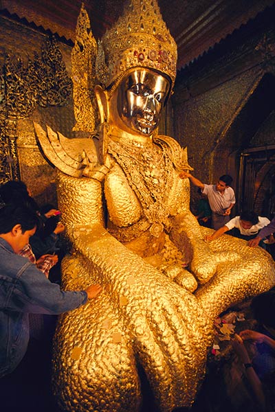 Pilgrimer som applicerar guldblad på Maha Muni Buddha Mandalay, Burma