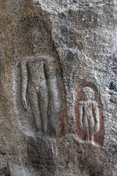 Parete della caverna scolpita con figura di Jain Tirthankara Adinatha