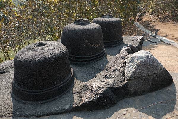 Trois stupas votifs bouddhistes sculptés dans un seul rocher