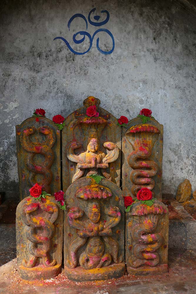 معبد بهوجا نانديشوارا شيفا ، أيقونات شيفا صغيرة مكتوب عليها OM على الحائط أعلاه ، ناندي