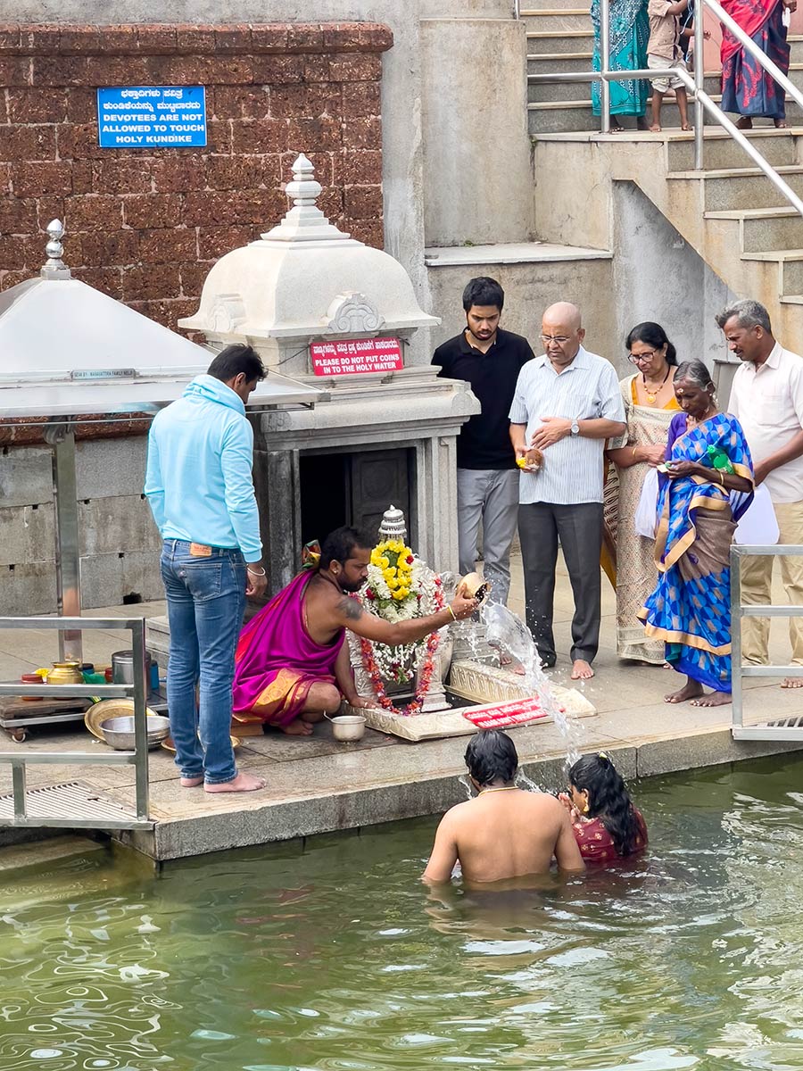 कावेरी नदी के उद्गम पर स्थित तालाकावेरी मंदिर, पुजारी तीर्थयात्रियों के साथ समारोह आयोजित करते हुए