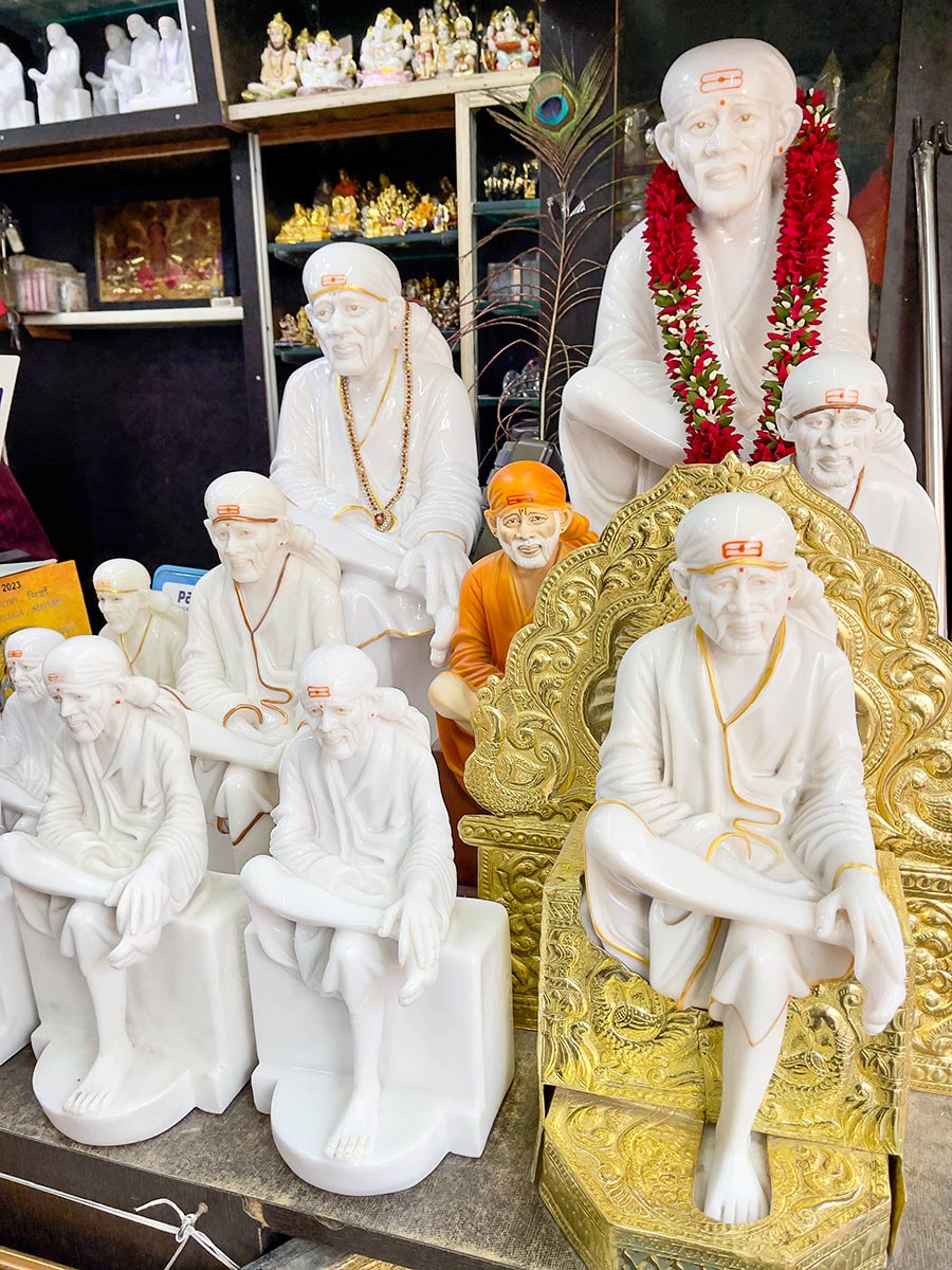 Shirdi Sai Baba Samadhi Mandir, Shirdi. Pienet Sai Baban patsaat myytävänä temppelin luona.