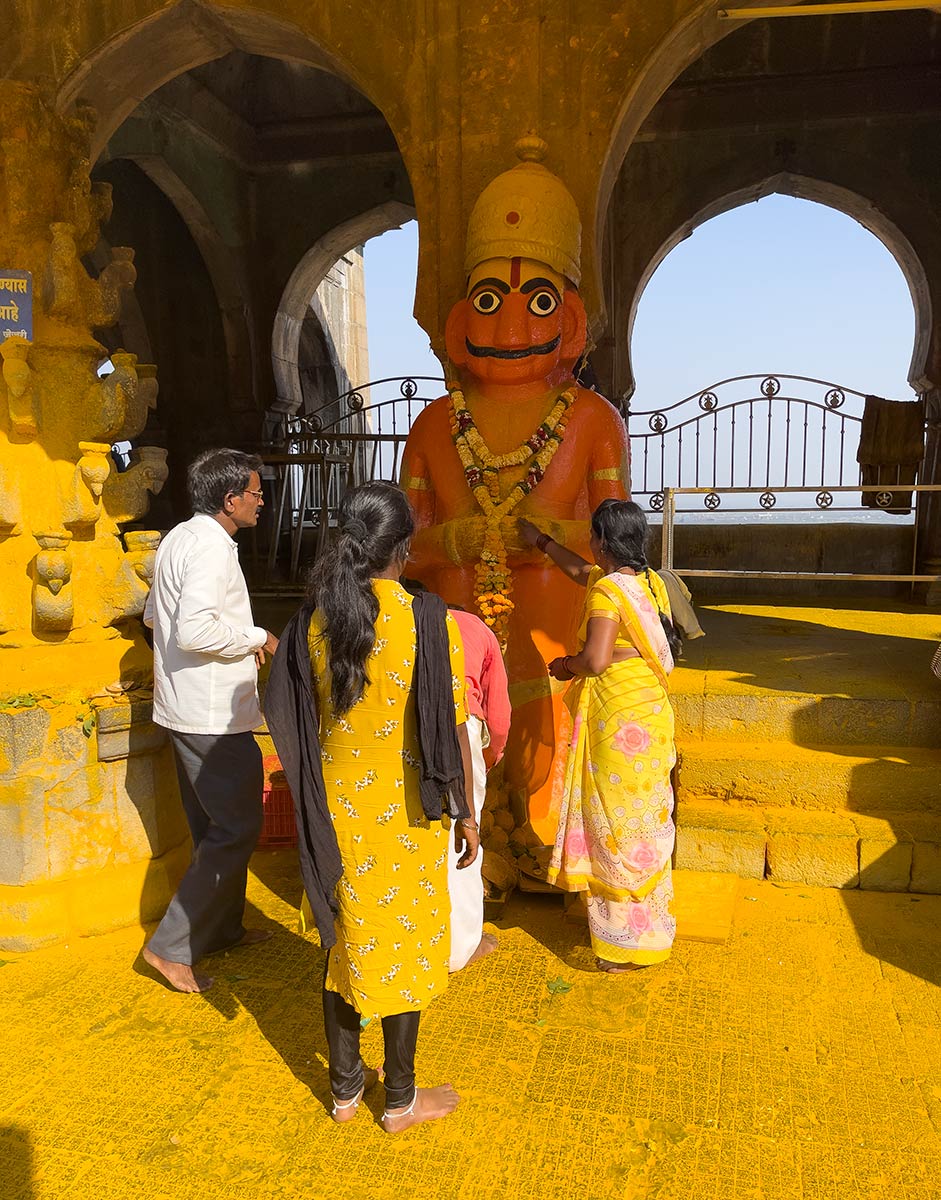 Shri Khandoba Marthanda Bhairava Mandir, Jejuri. Pellegrini che mettono polvere di curcuma sulla statua di Khandoba.