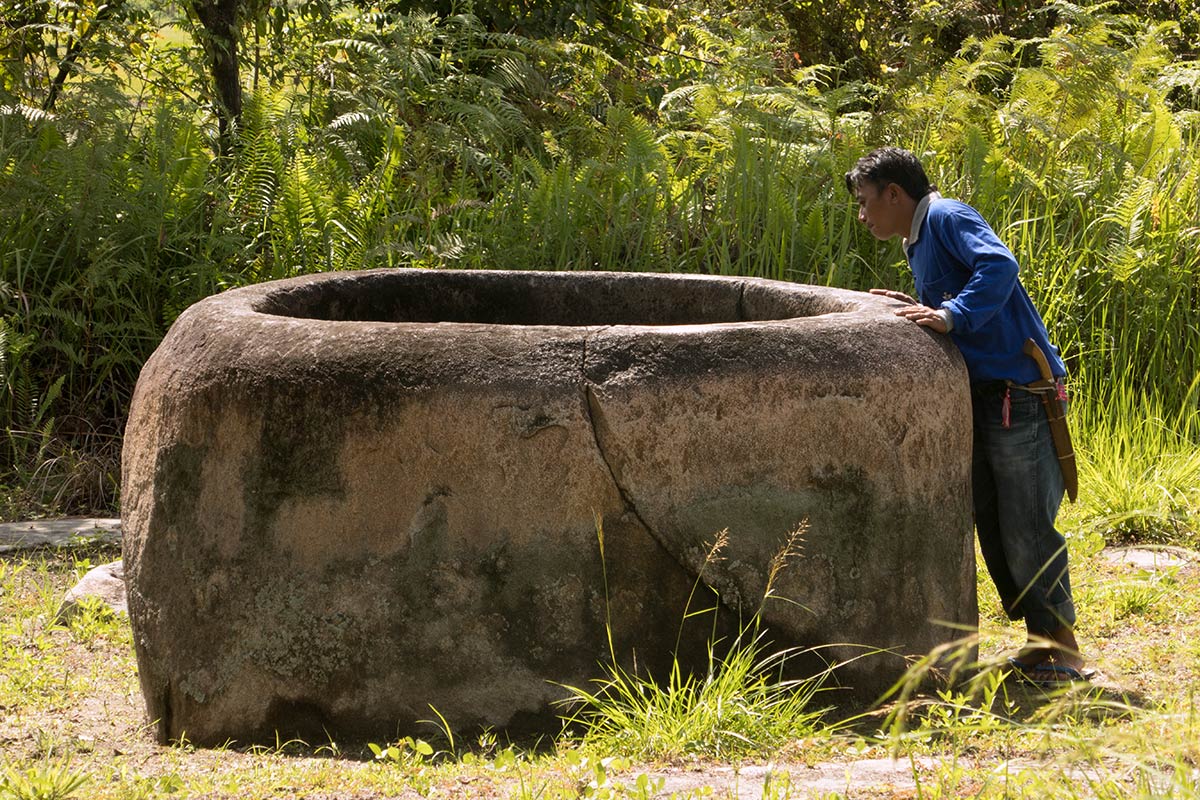 Uomo indonesiano che ispeziona un kalamba vicino al villaggio di Kolori, Valle del Bada