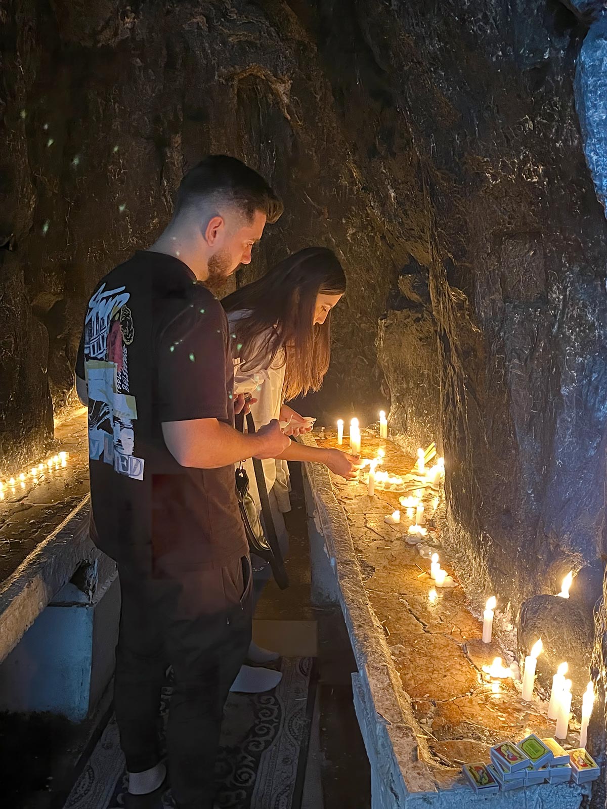 Pellegrini che accendono candele nella camera principale della grotta, Tekke di Sari Salltiku, Mali I Krujes