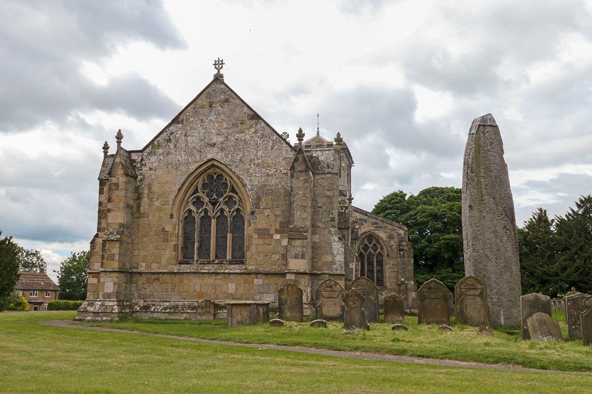 Rudston Church och forntida monolit på kyrkogården
