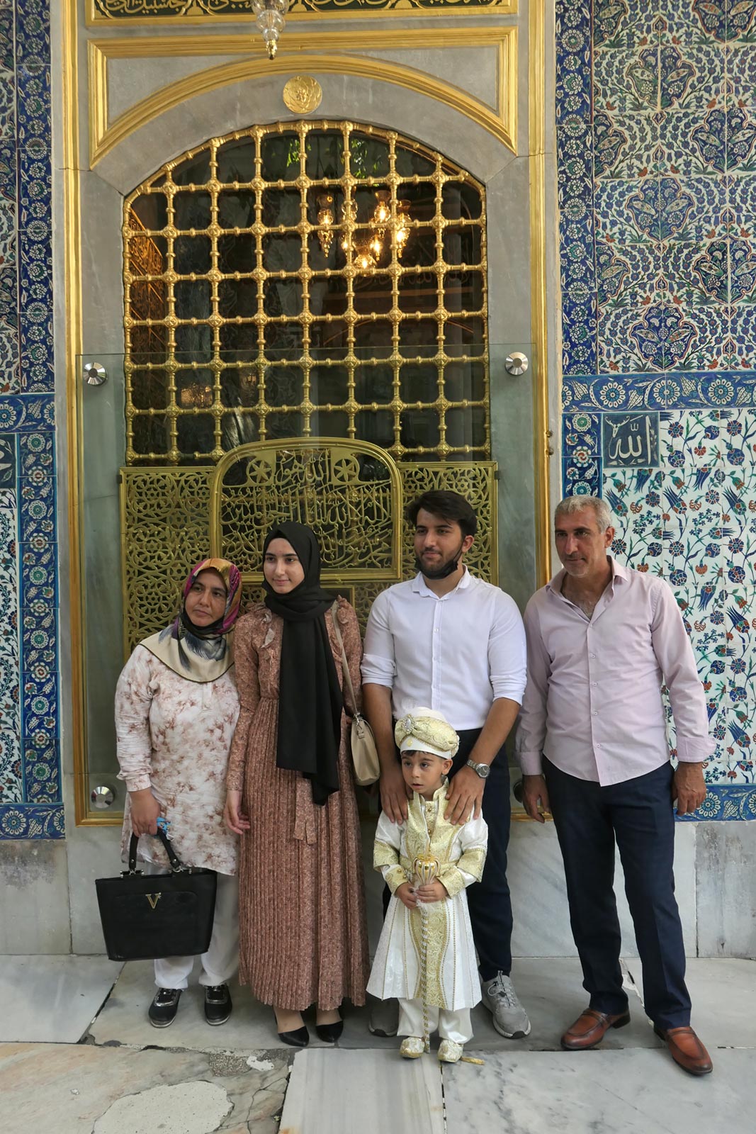Familj poserar för fotografi vid Shrine of Eyup Sultan, Istanbul